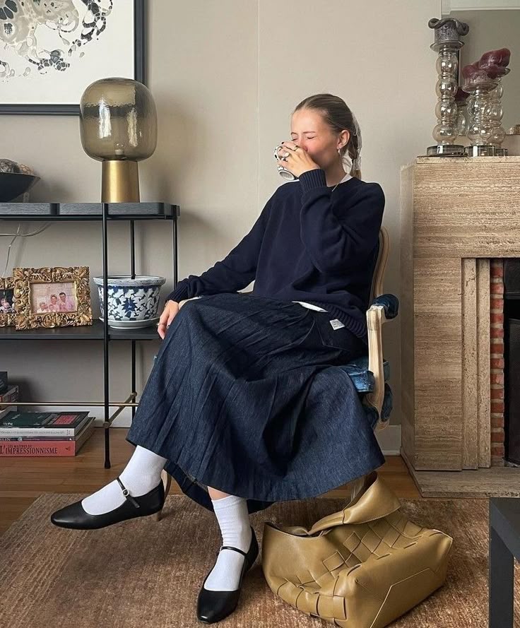 Look rom&acirc;ntico com saia plissada, su&eacute;ter e sapatilha com meia branca