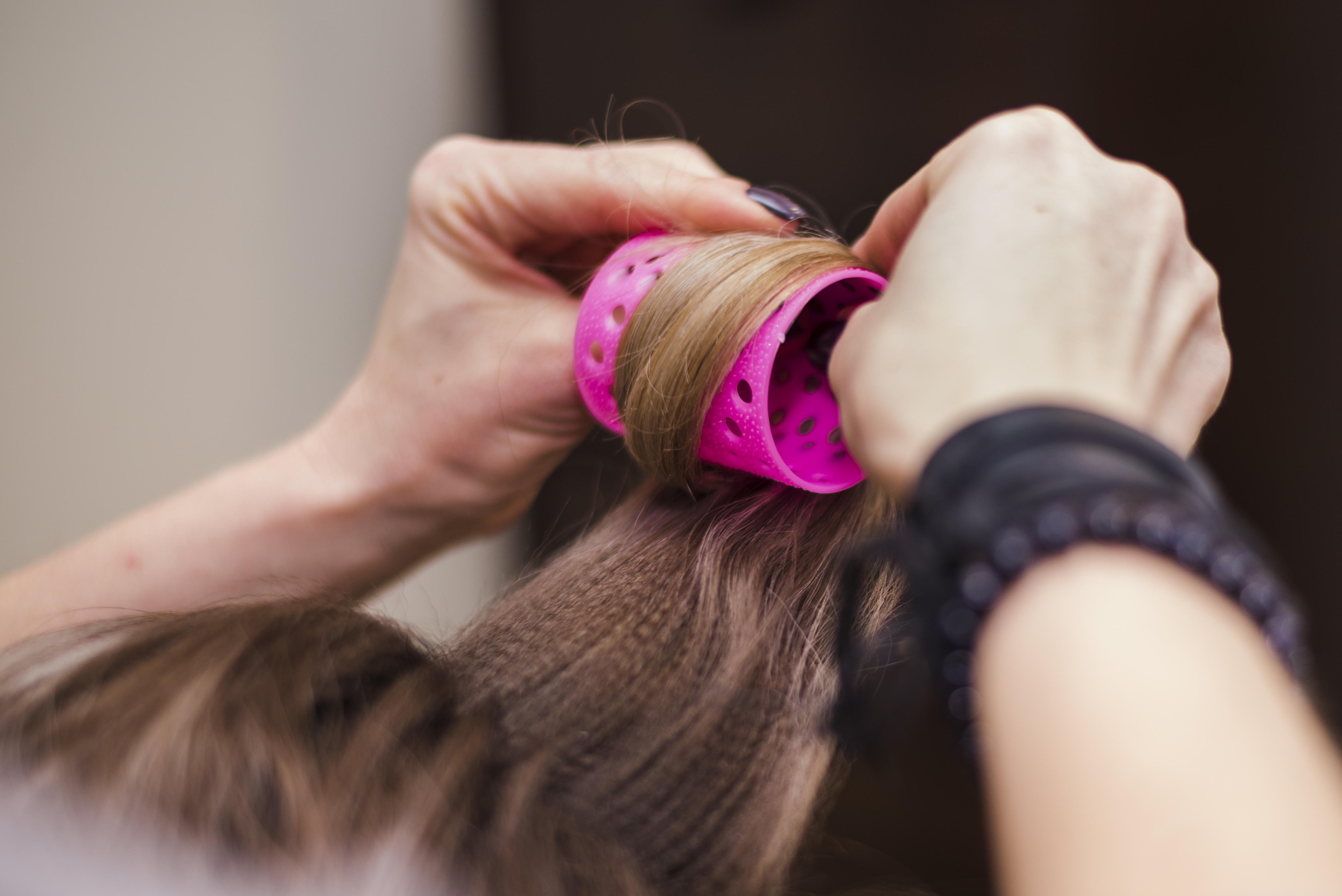 Imagem de cabelo sendo enrolado em bobe.