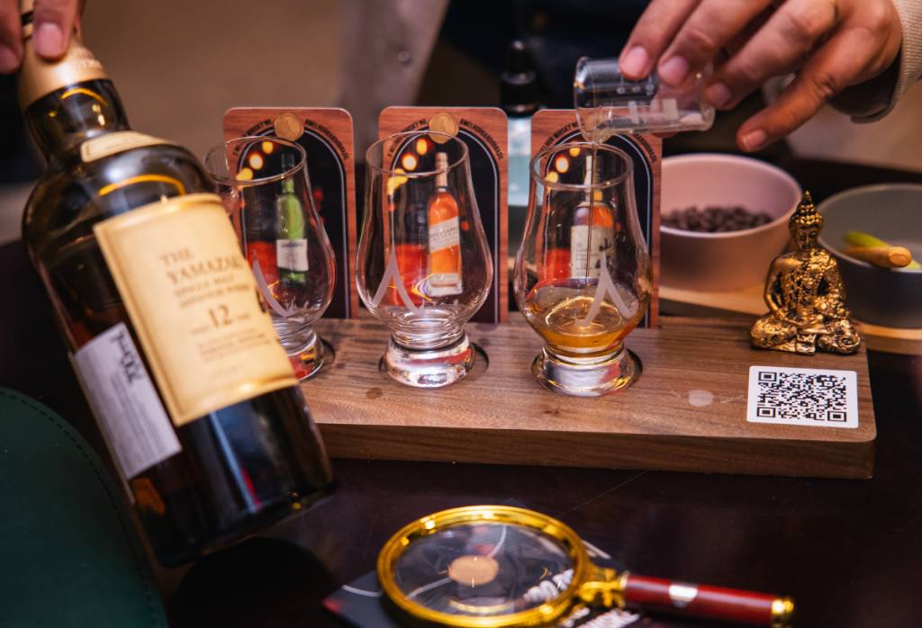 As garrafas dos uísques escolhidos pelos clientes são levadas à mesa e o rótulo pode ser lido com a lupa