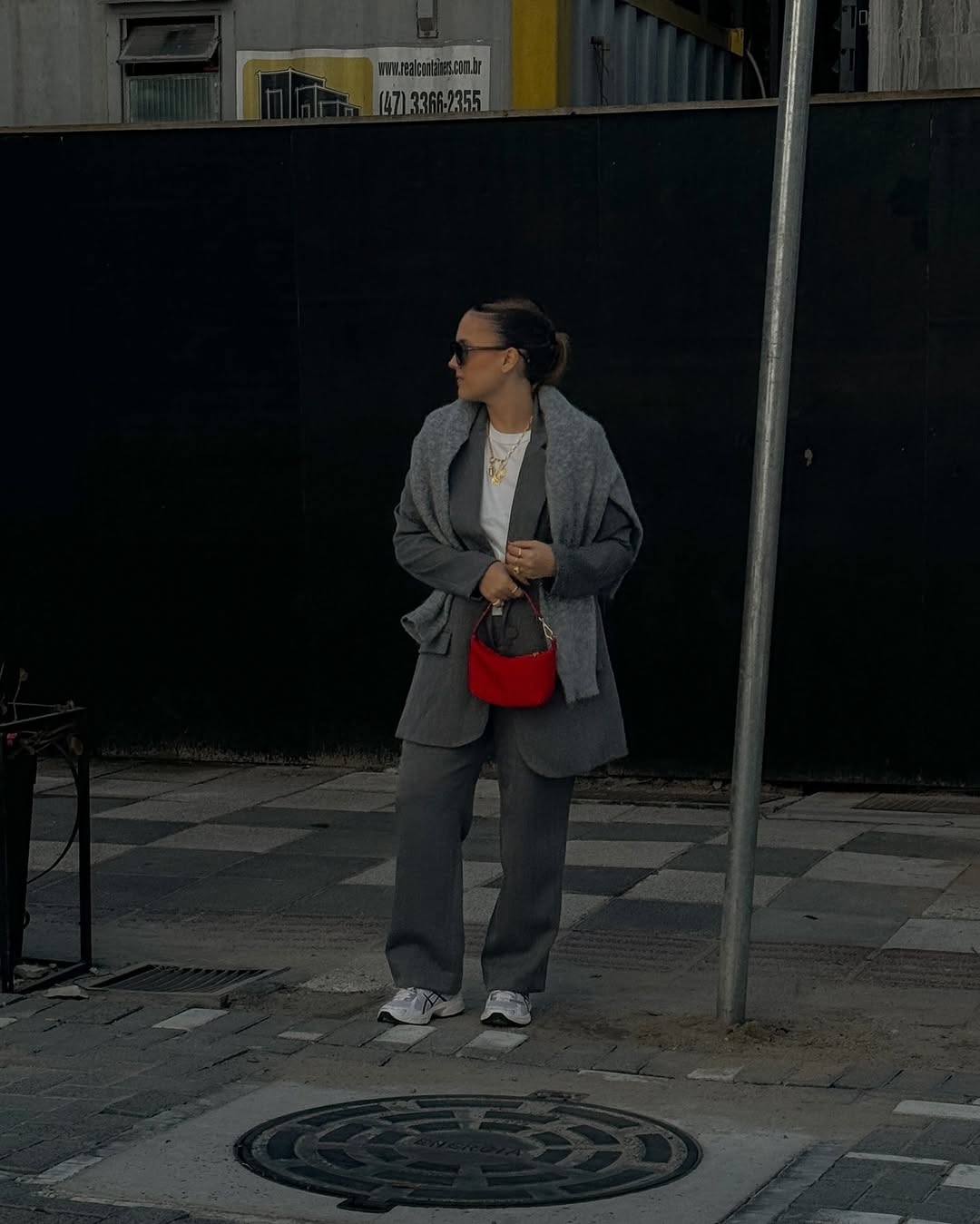 Look monocrom&aacute;tico cinza com bolsa vermelha e t&ecirc;nis esportivo