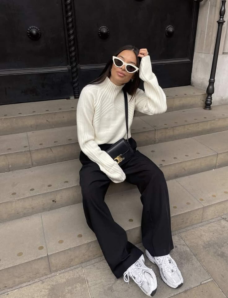 Look com cal&ccedil;a preta, su&eacute;ter off-white e t&ecirc;nis esportivo branco