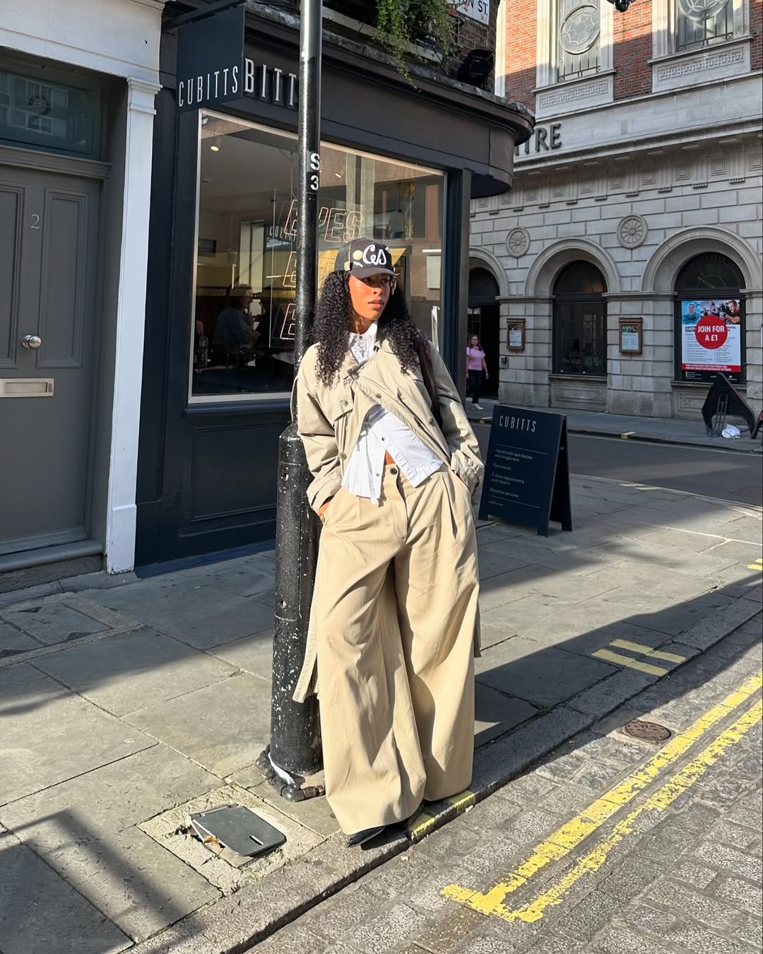 Look com bon&eacute; preto e trench coat bege oversized