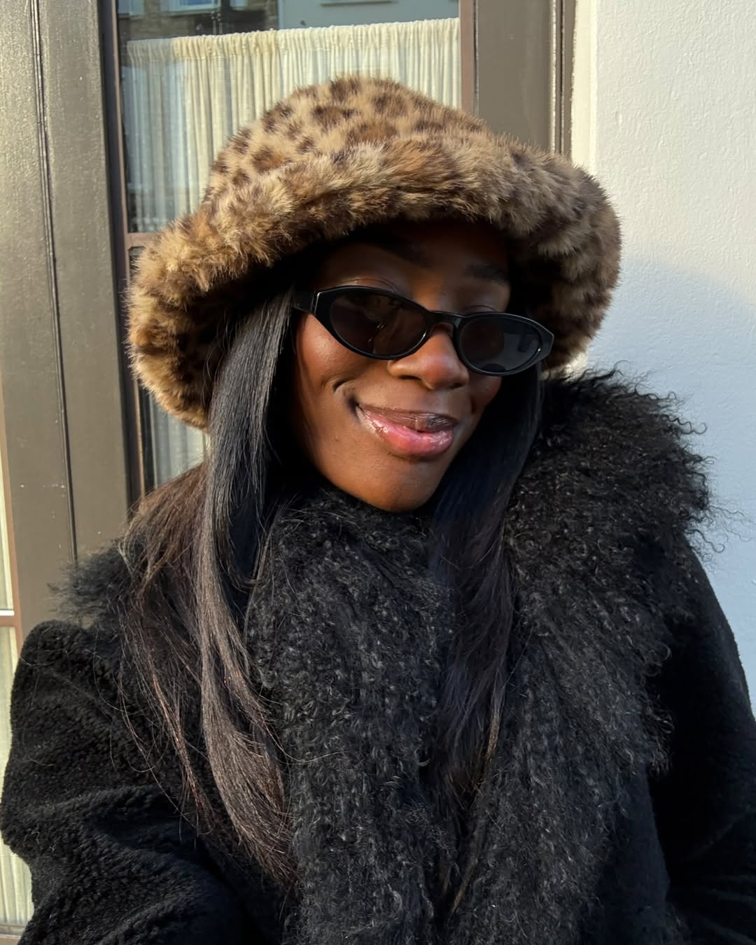 Look com chap&eacute;u peludo de oncinha e casaco preto