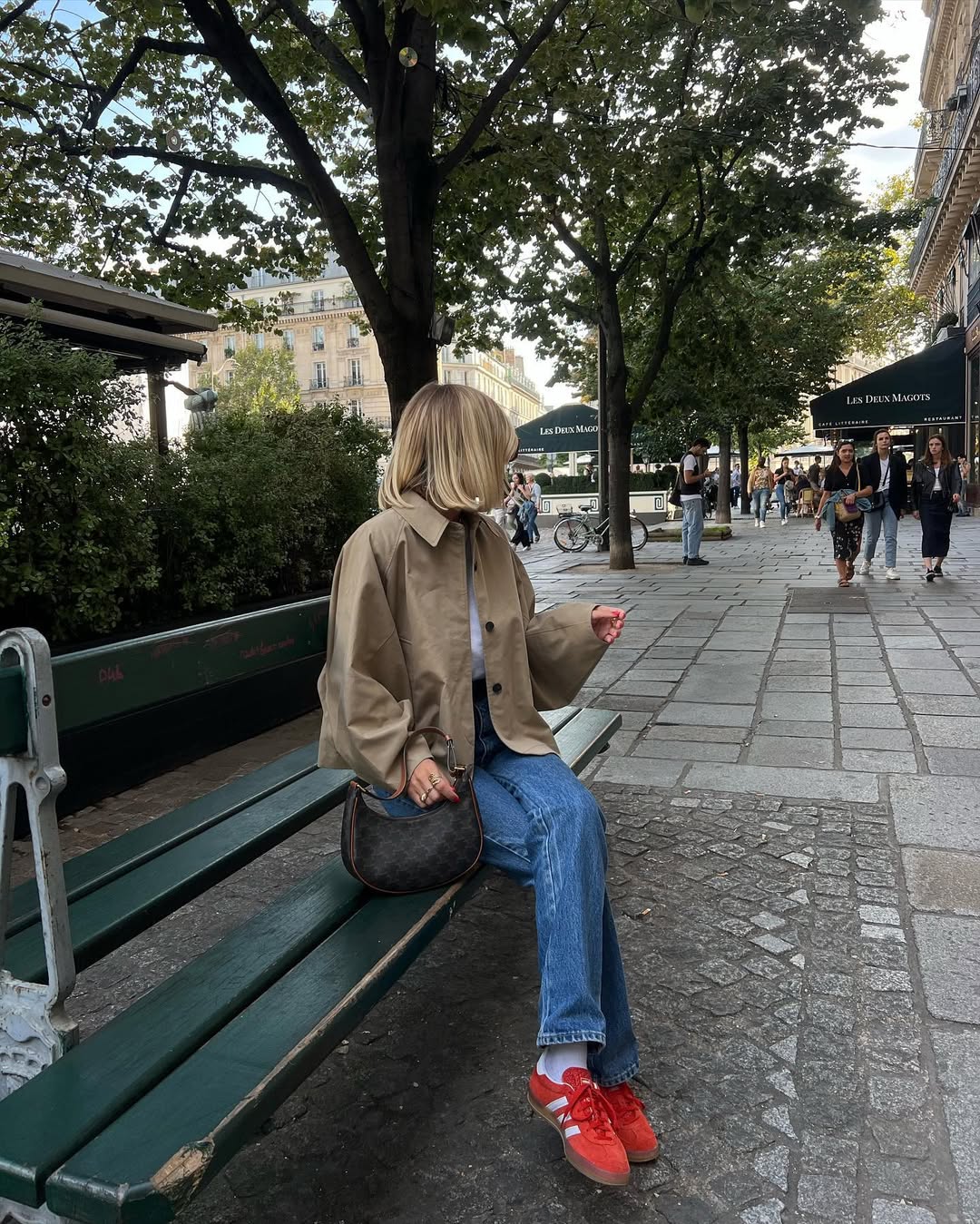 Look com trench coat bege, jeans e t&ecirc;nis vermelho