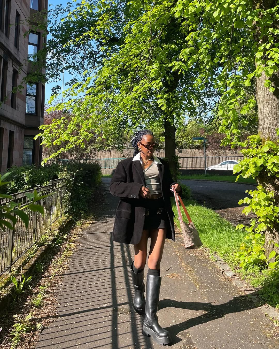 Saia curta com blazer oversized e bota de cano longo no inverno