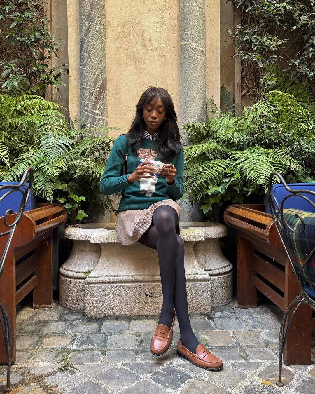 Saia curta com su&eacute;ter verde e mocassim para dias frios