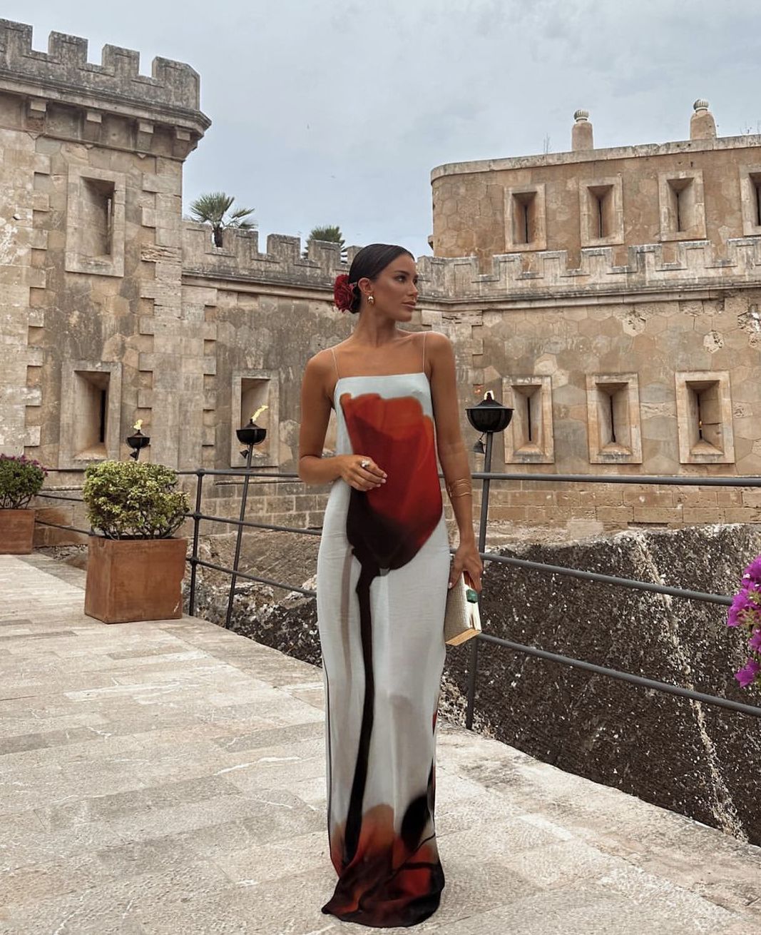 Imagem de mulher usando vestido longo maxi estampa floral vermelho e branco.