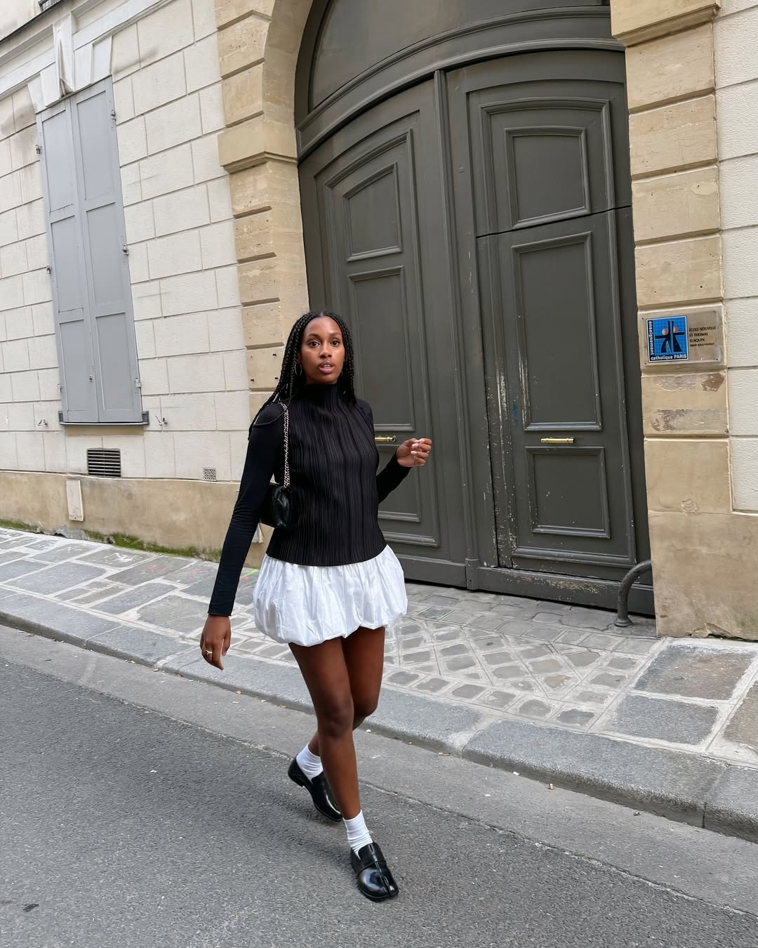 Blusa e sapato preto em look casual com saia branca