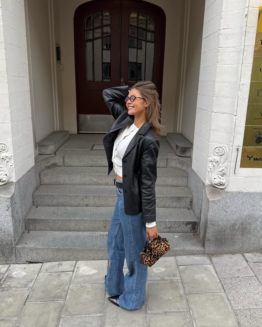 Look com blazer de couro, jeans e scarpin preto