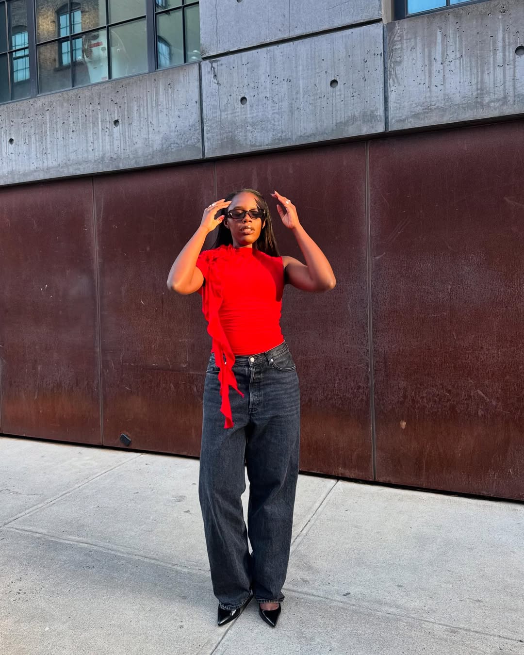 Look com blusa vermelha, jeans preto e scarpin preto