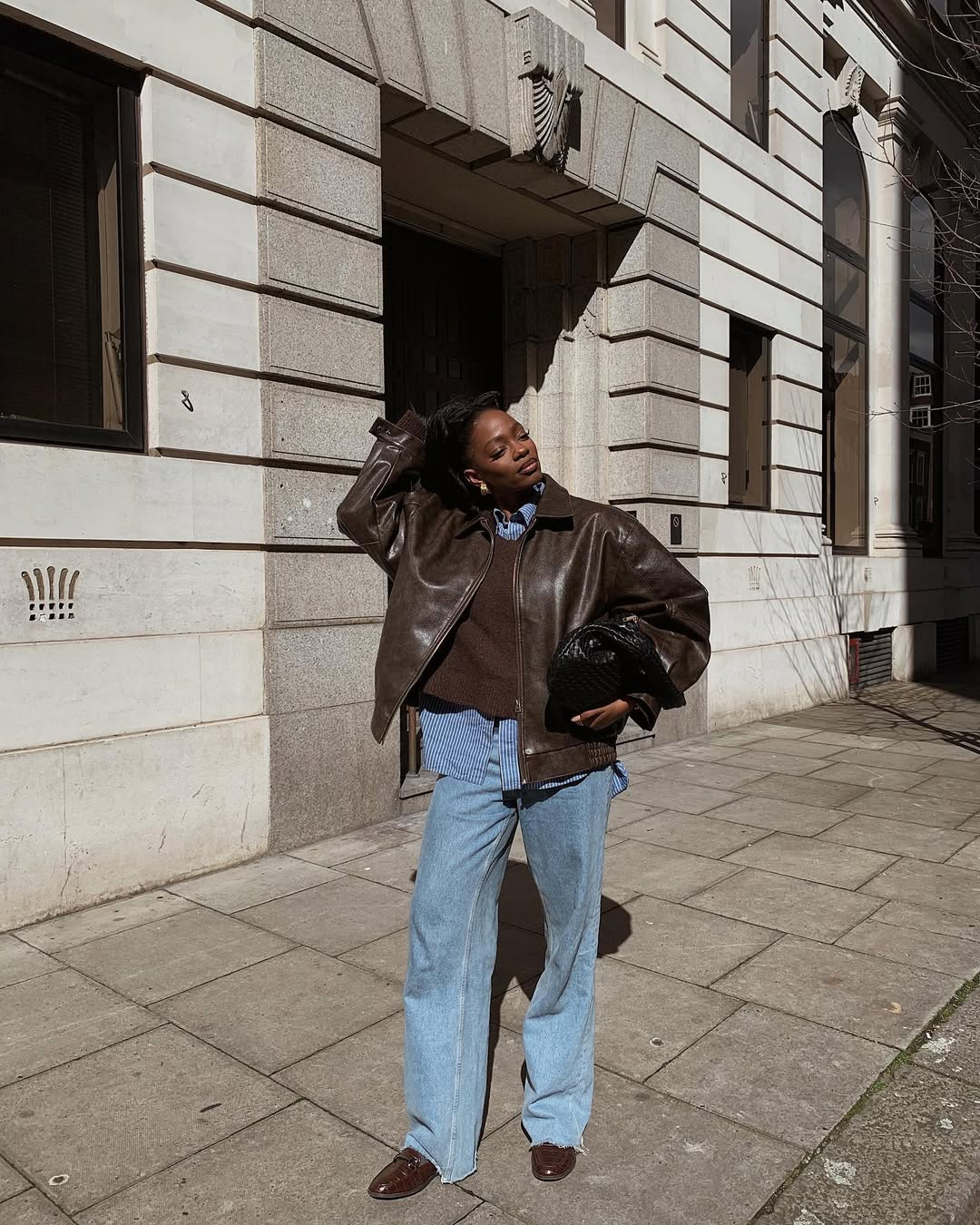 Imagem de visual com sobreposi&ccedil;&atilde;o de camisa azul com jaqueta marrom de couro.