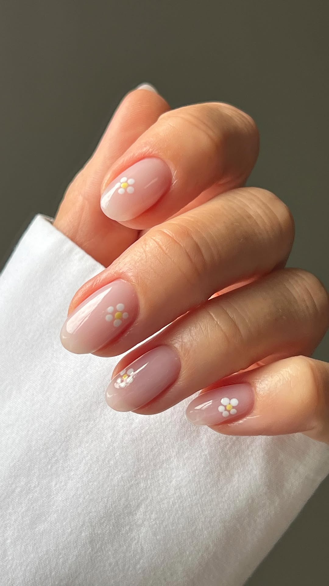 Unhas claras com nail art de margaridas