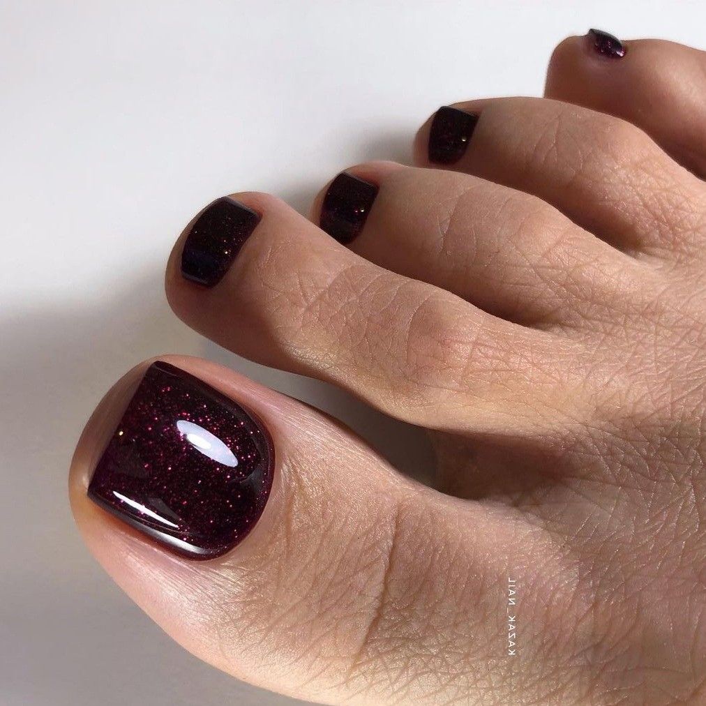 Unhas do p&eacute; decorada, com esmalta&ccedil;&atilde;o vinho com brilho/glitter.