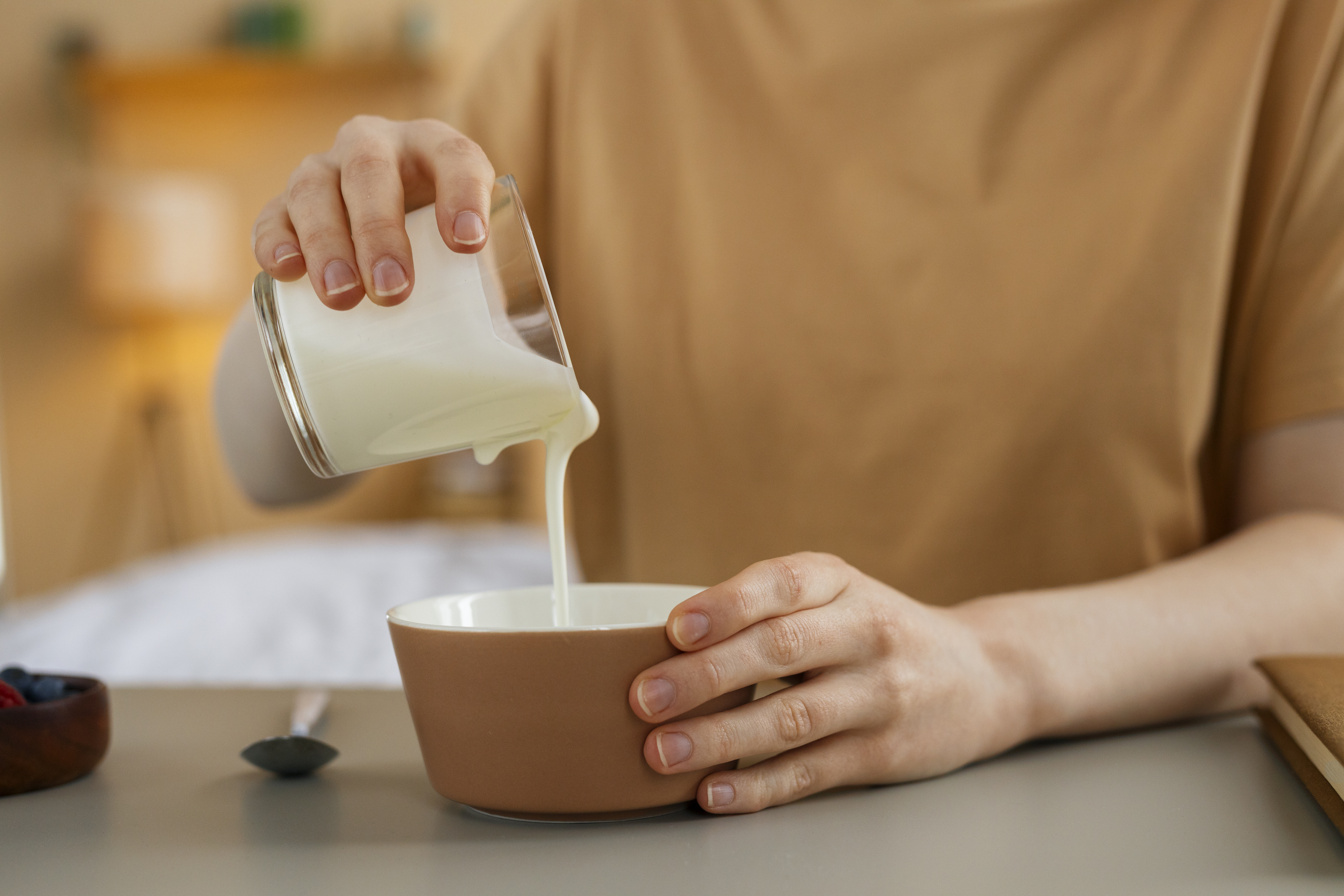 Imagem de m&atilde;o feminina despejando leite condensado em uma tijela