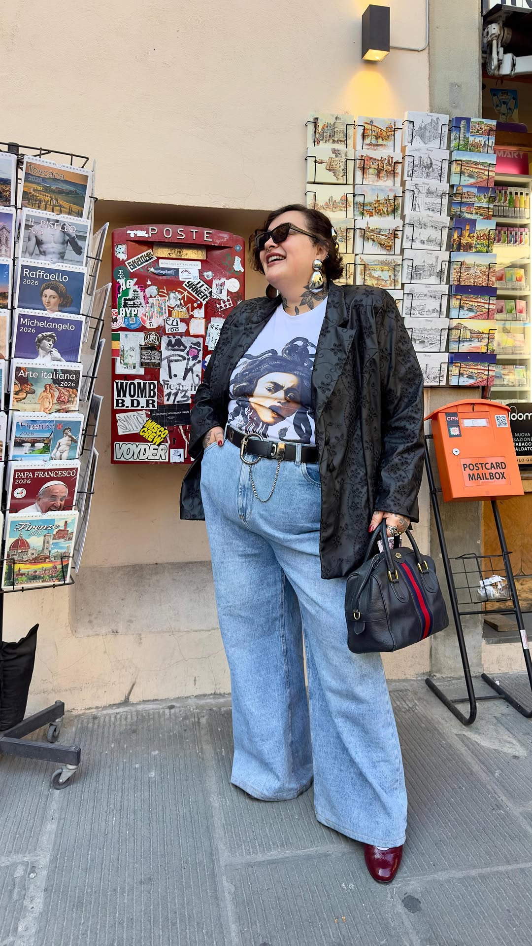 Look plus size com blazer preto estampado, camiseta gr&aacute;fica e jeans claro