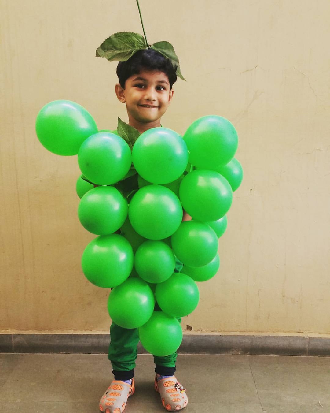 Fantasia infantil de uva feita com bal&otilde;es verdes