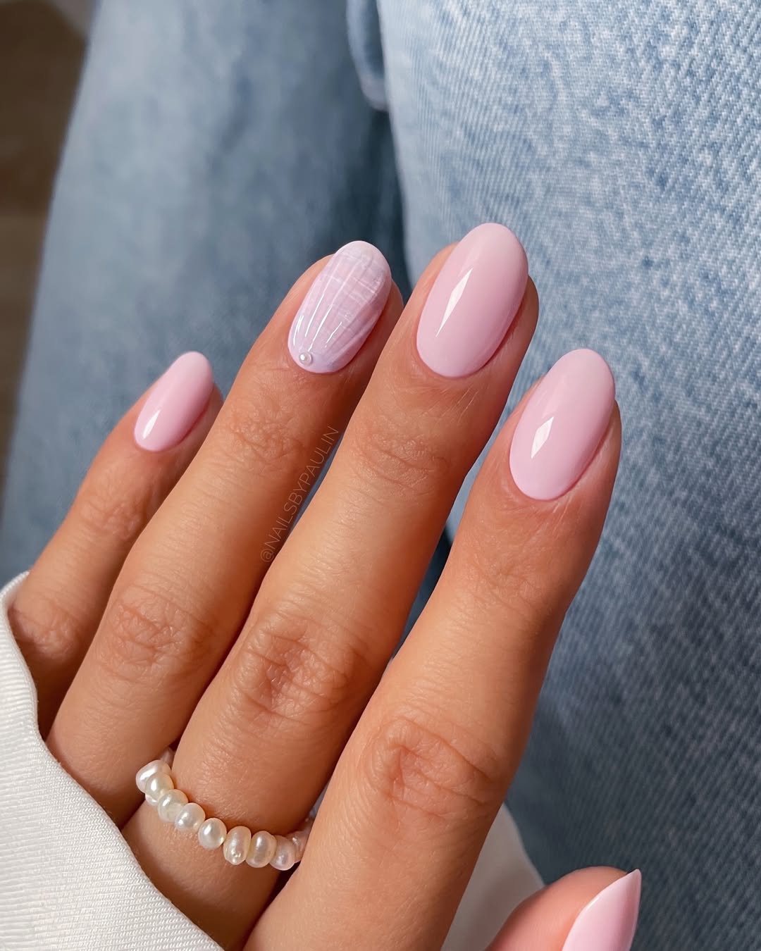 Imagem mostra unhas decoradas delicadas com esmalta&ccedil;&atilde;o rosa e branco, e conchas.