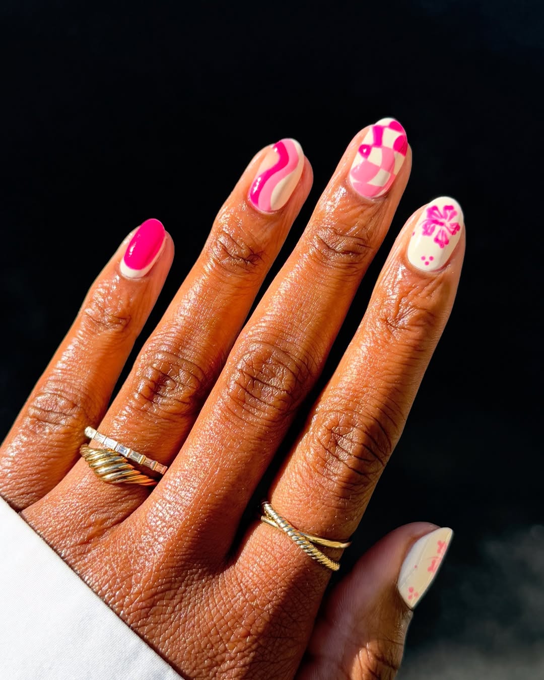 Imagem mostra unhas decoradas ousadas com esmalta&ccedil;&atilde;o rosa e branco.