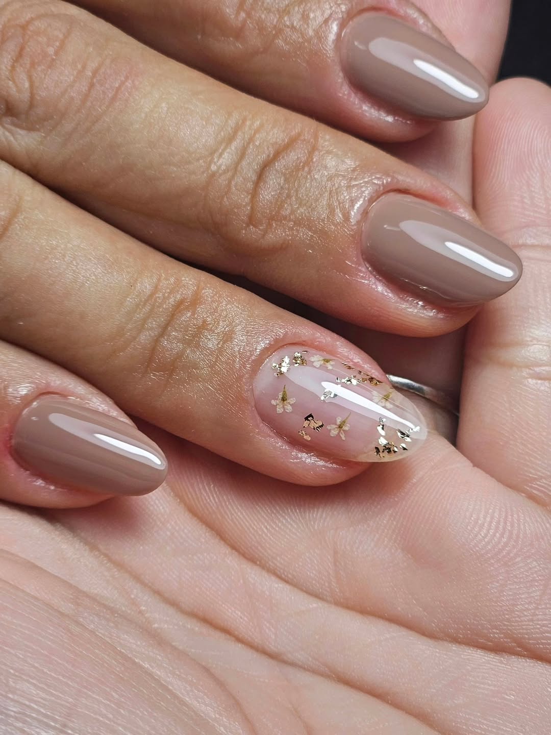 Unhas nude decoradas com aplica&ccedil;&otilde;es de flores douradas