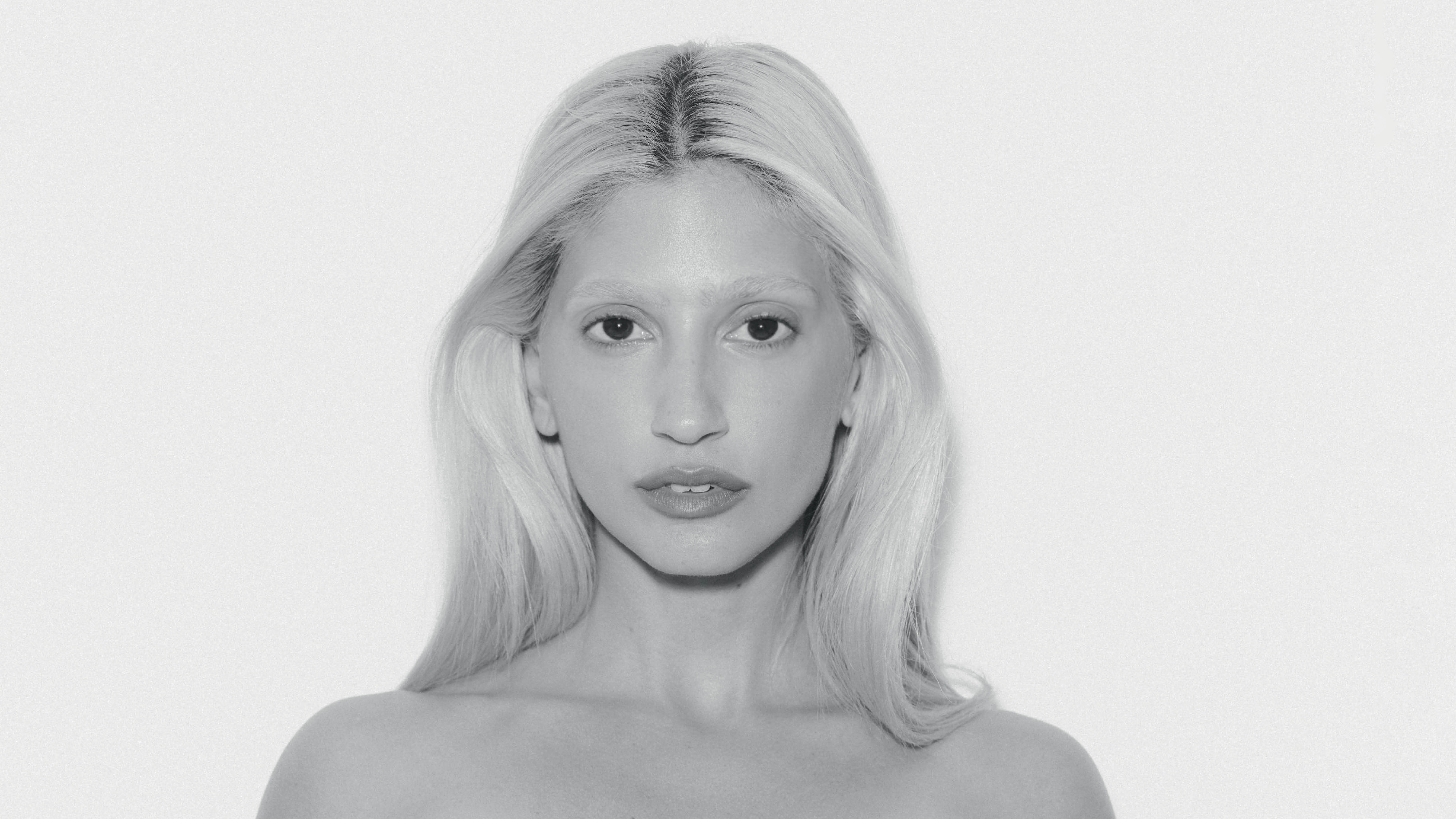 Imagem preta e branca da influenciadora Bertha Jucá vistaa de frente do percoço para cima