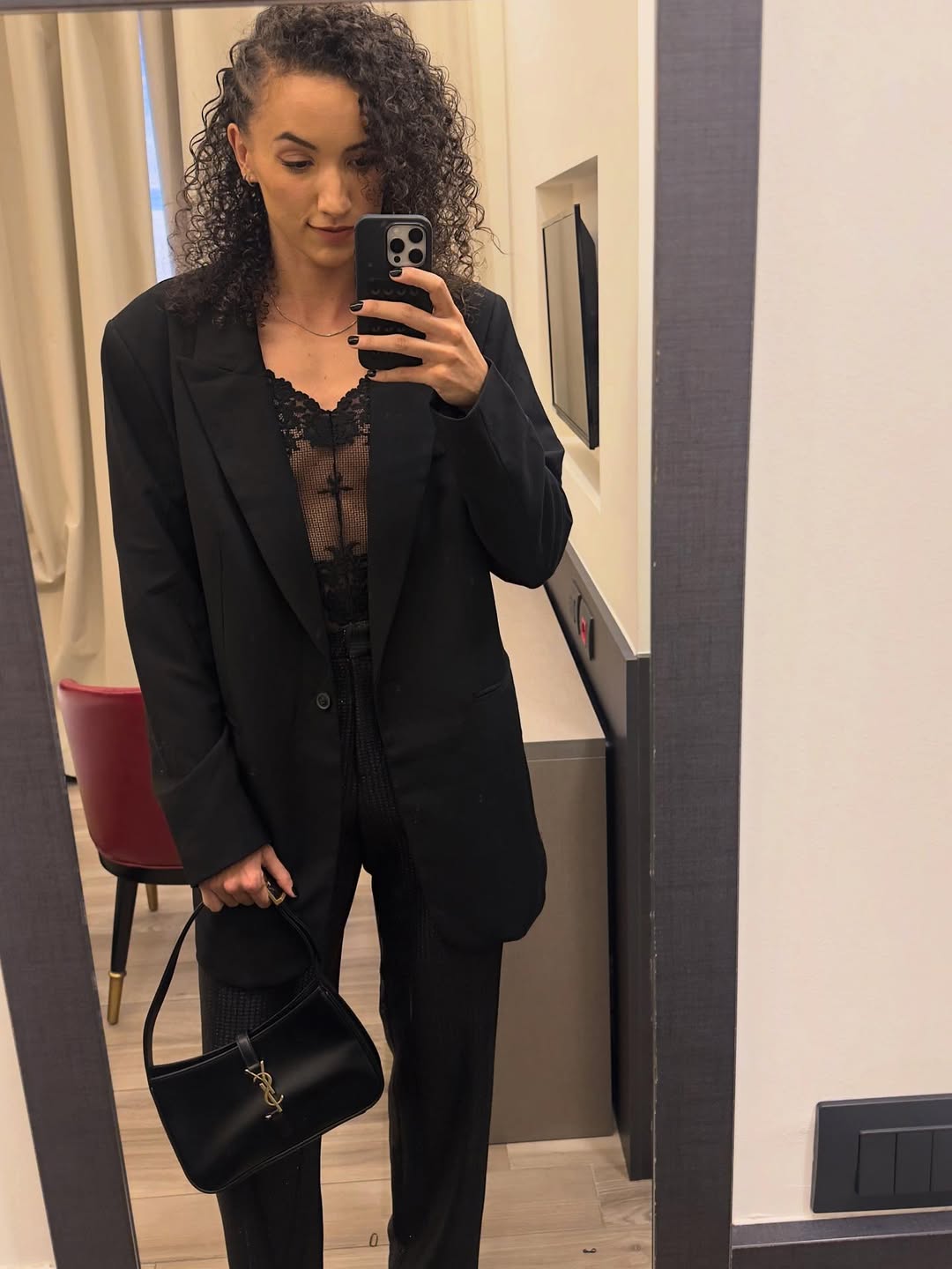 Imagem da jogadora de v&ocirc;lei Gabi Guimar&atilde;es vestida com alfaitaria preta e bolsa YSL.