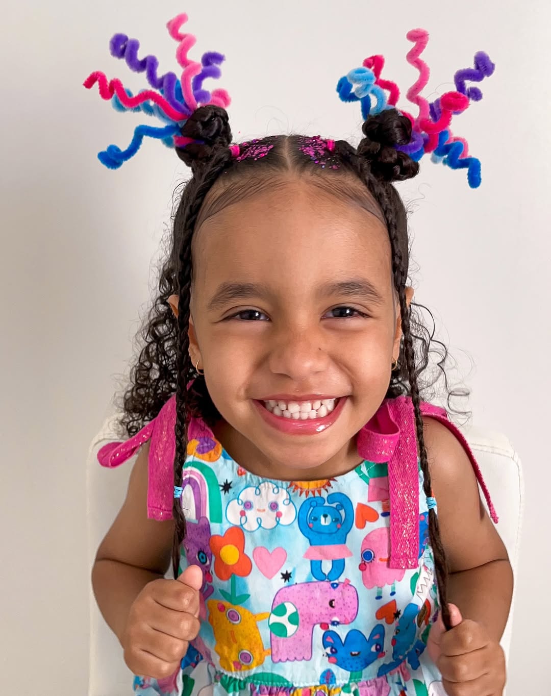 Penteado de cabelo cacheado com fios coloridos e acess&oacute;rios vibrantes