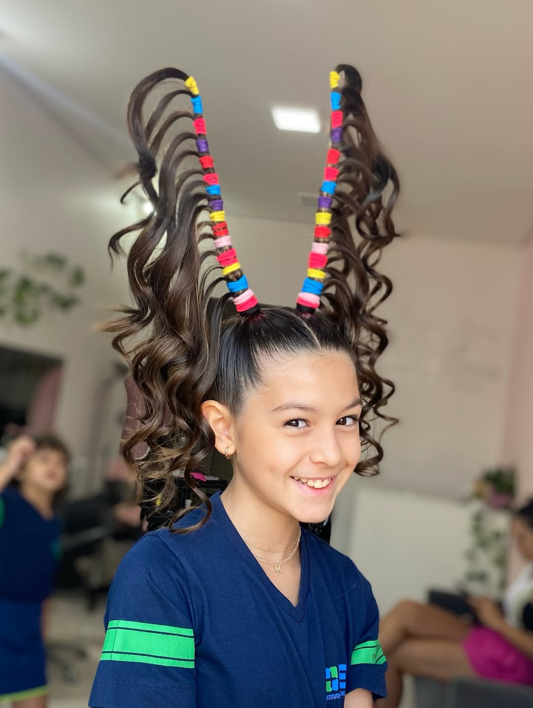 Penteado com antenas coloridas em cabelo cacheado