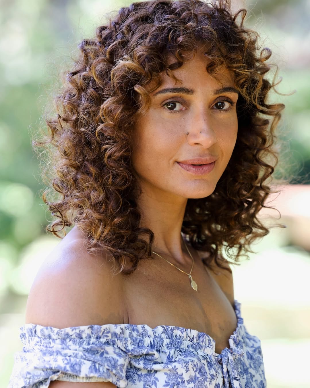 Foto de Camila Pintada com cabelo castanho, cacheado e com franja