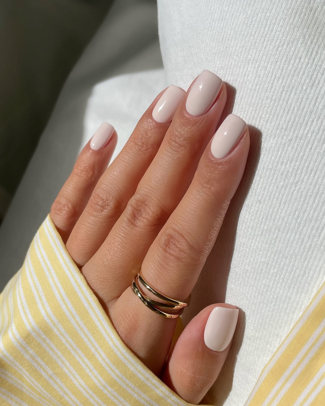 Imagem mostra unhas quadradas curtas com esmalte branco.