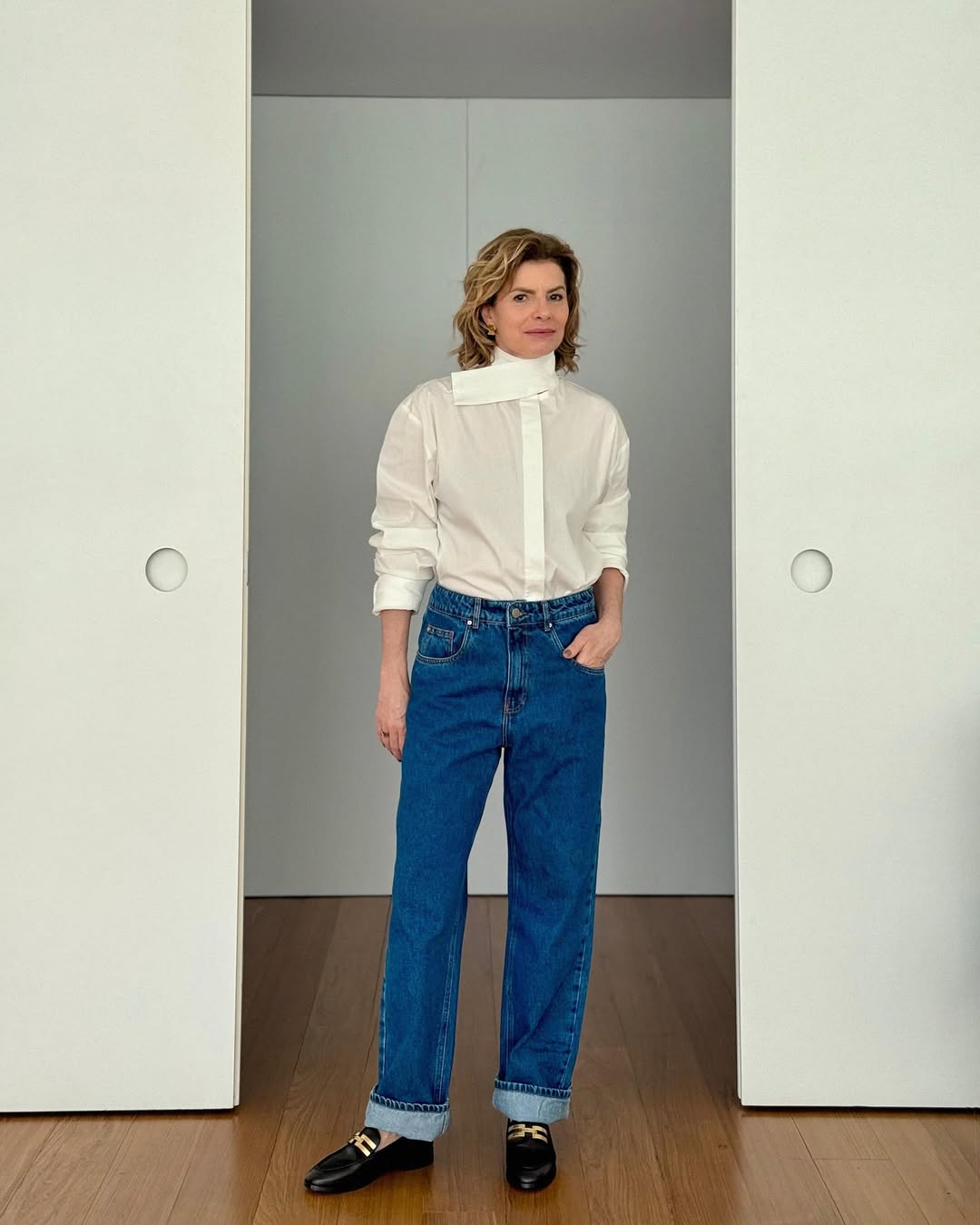 Foto de Debora Bloch usando um look composto por camisa branca, cal&ccedil;a jeans azul e mocassim