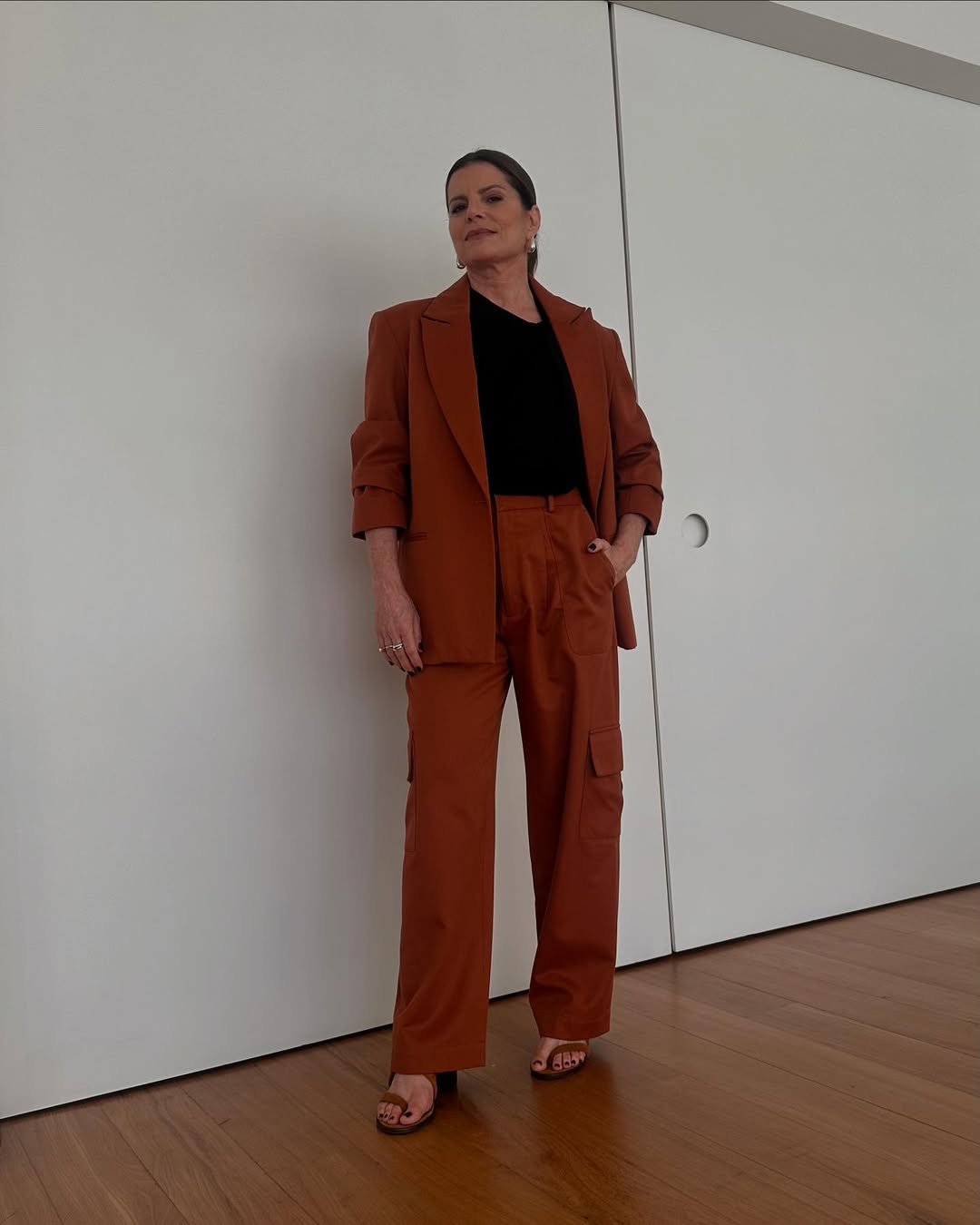 Foto de Debora Bloch usando um look composto por conjuntinho de blazer e cal&ccedil;a vermelho, al&eacute;m de blusa preta e salto preto
