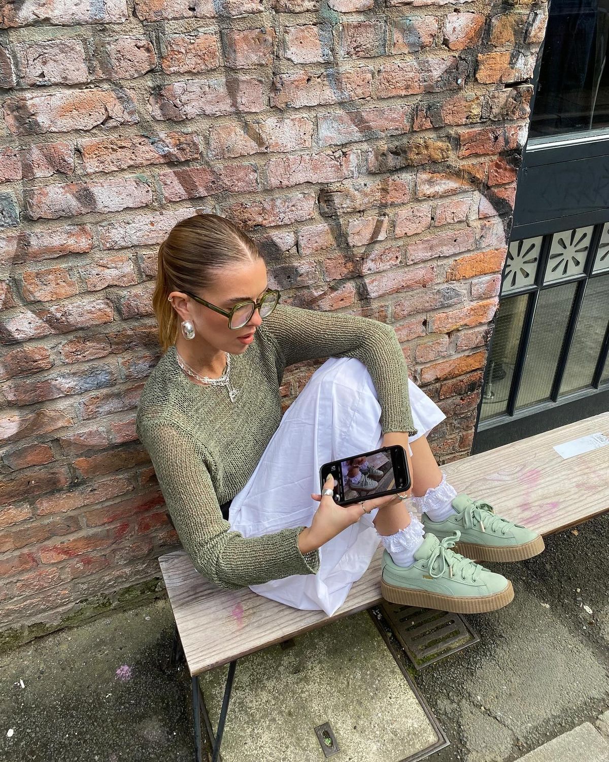 Foto de uma mulher usando um look composto por blusa, saia branca e t&ecirc;nis verde pistache