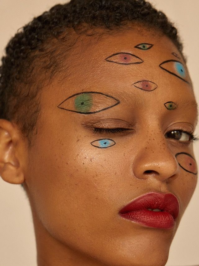 Maquiagem art&iacute;stica com olhos desenhados no rosto para o Halloween