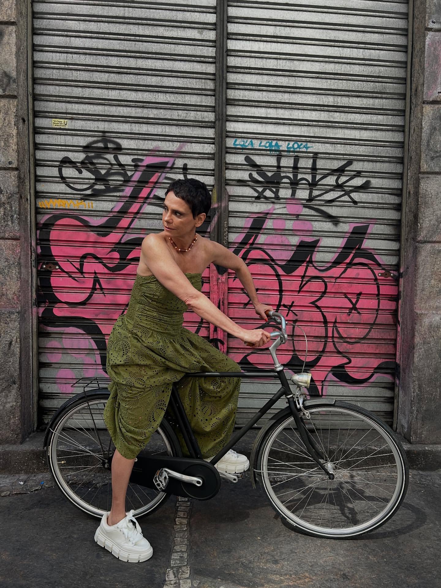 Foto de Malu Galli usando um look composto por vestido longo verde e t&ecirc;nis branco
