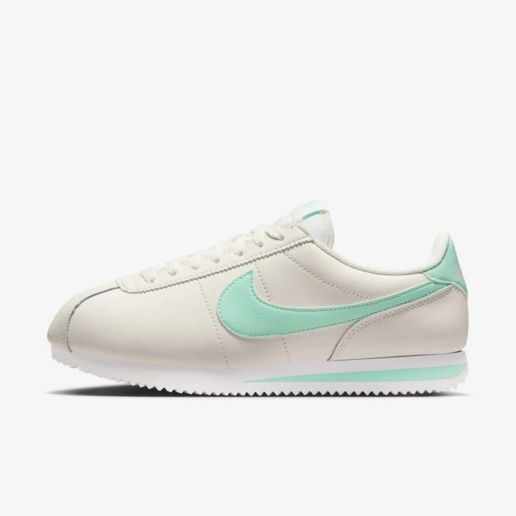 Foto de um tênis branco da Nike com detalhes verde