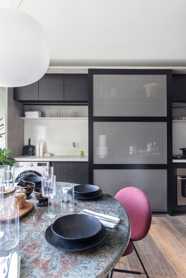 Sala de estar com porta de correr que esconde ora lavanderia, ora o bar.