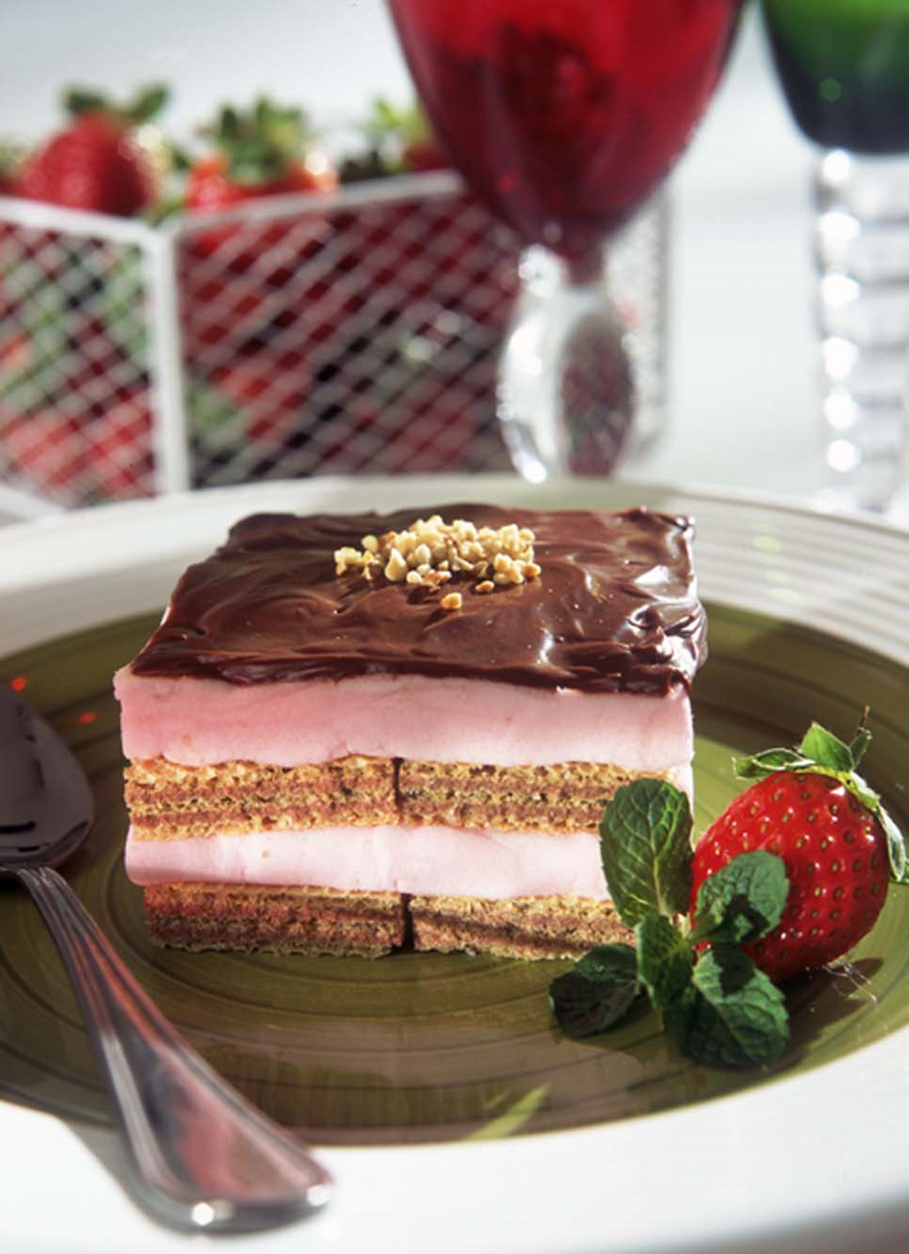 Pav&ecirc; montado em camadas de wafer de chocolate e sorvete de morango, coberto por ganache de chocolate escuro. A fatia mostra altern&acirc;ncia de biscoito e sorvete, com farofa crocante ao redor