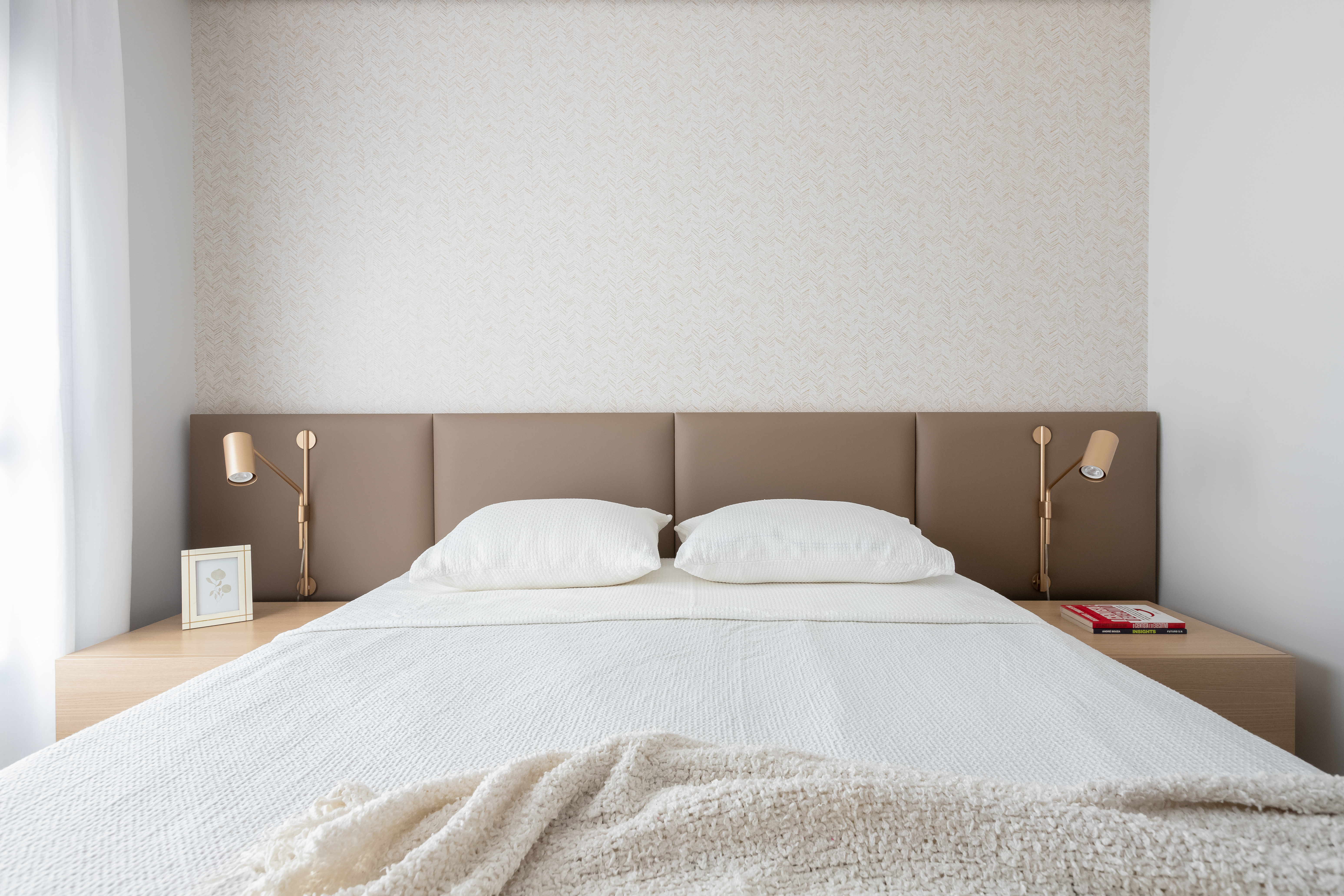 Quarto de casal minimalista em cores neutras com cabeceira almofadada marrom