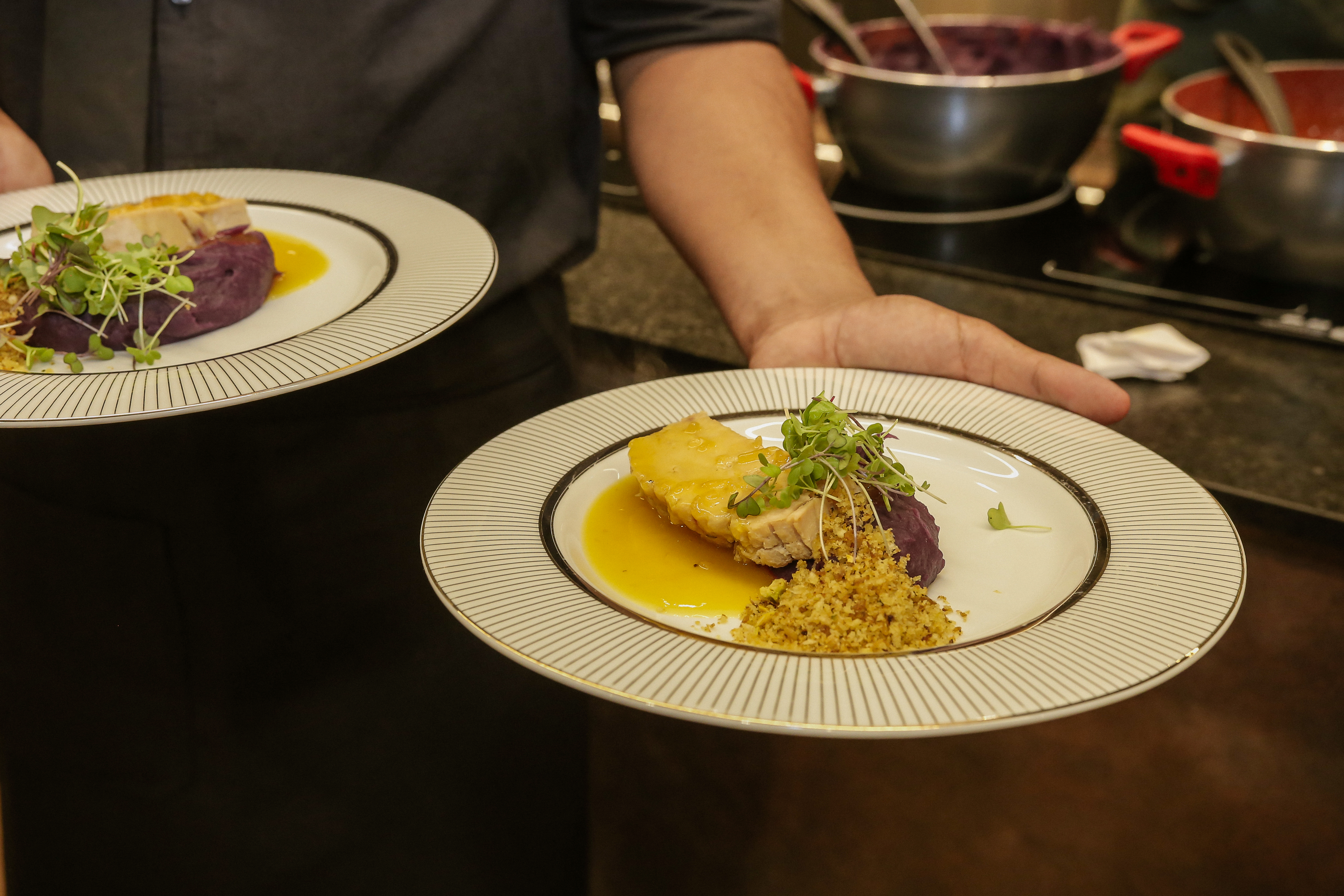 Pessoa segurando prato de comida com peru, pur&ecirc; de batata e farofa