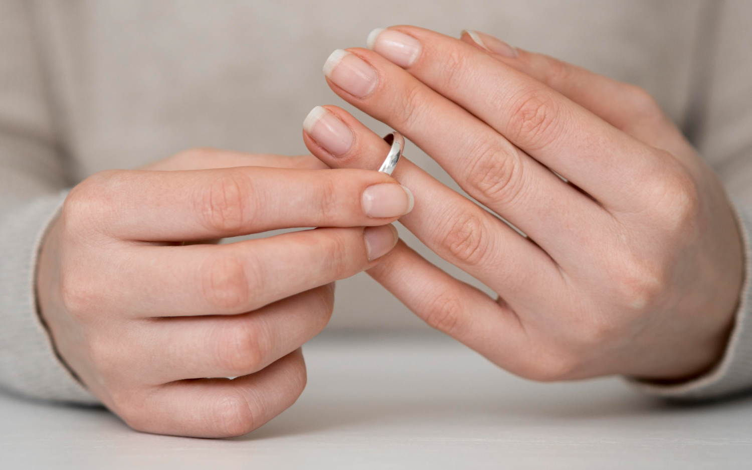 Imagem de mulher se libertando de relacionamento e tirando alian&ccedil;a