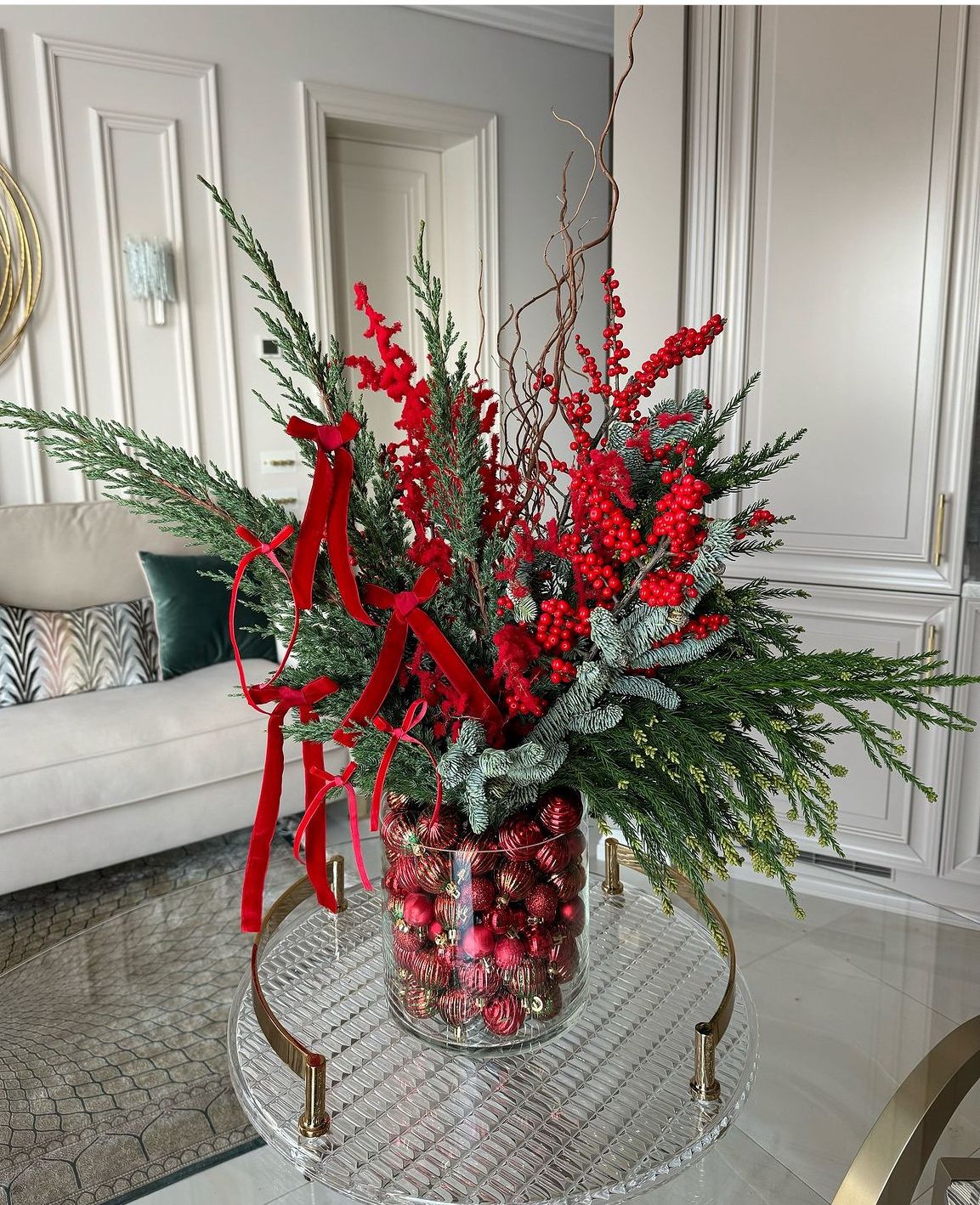 Imagem de arranjo de flores para decorar a casa no Natal com galhos de cerejinhas e la&ccedil;os envolvidos.