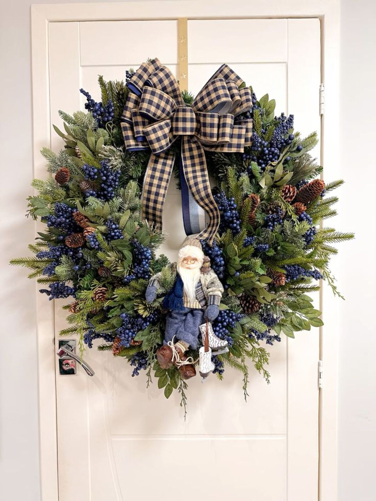 Imagem de guirlanda azul e verde, com la&ccedil;o, papai noel e plantinhas azuis.