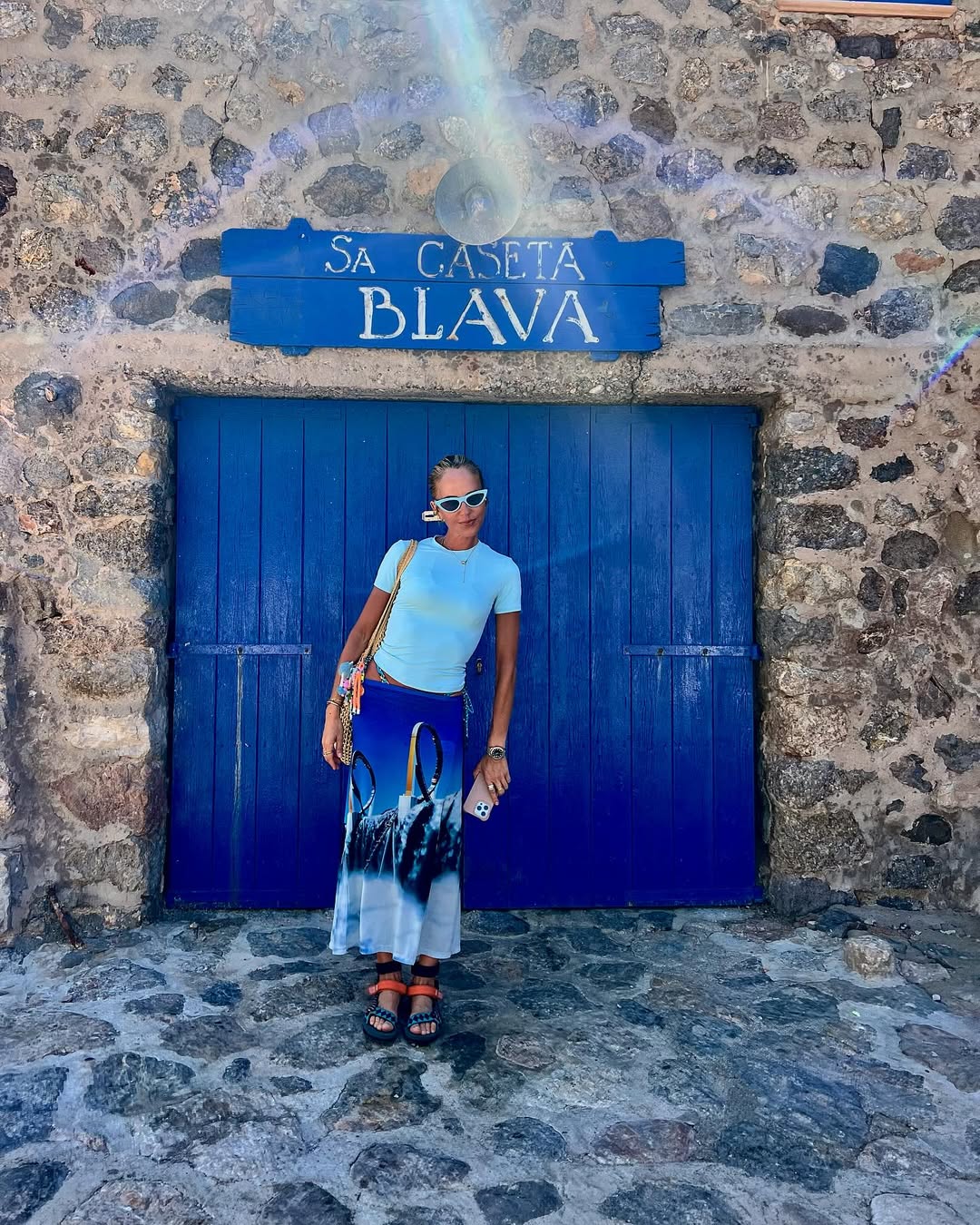 Look com camiseta azul-claro e saia estampada para ver&atilde;o moderno