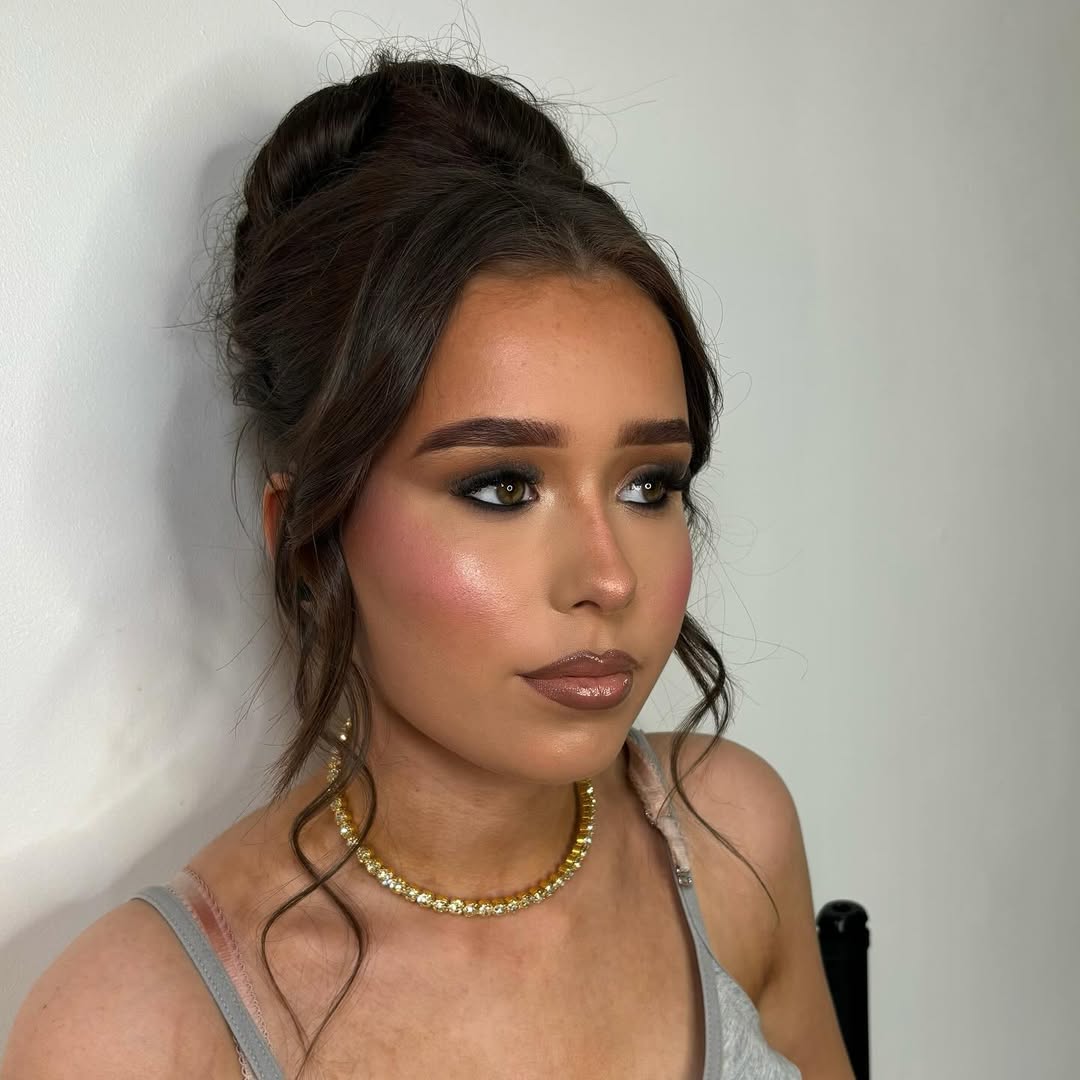 Maquiagem dourada para formatura com coque alto e pele iluminada