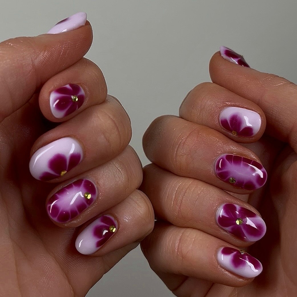 Unhas acrigel com flores 3D em tons de rosa e roxo