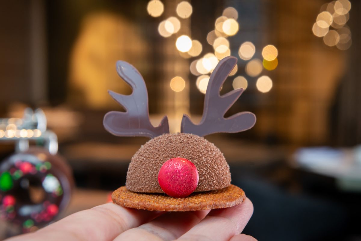 M&atilde;o segurando biscoito em formato de rena de natal