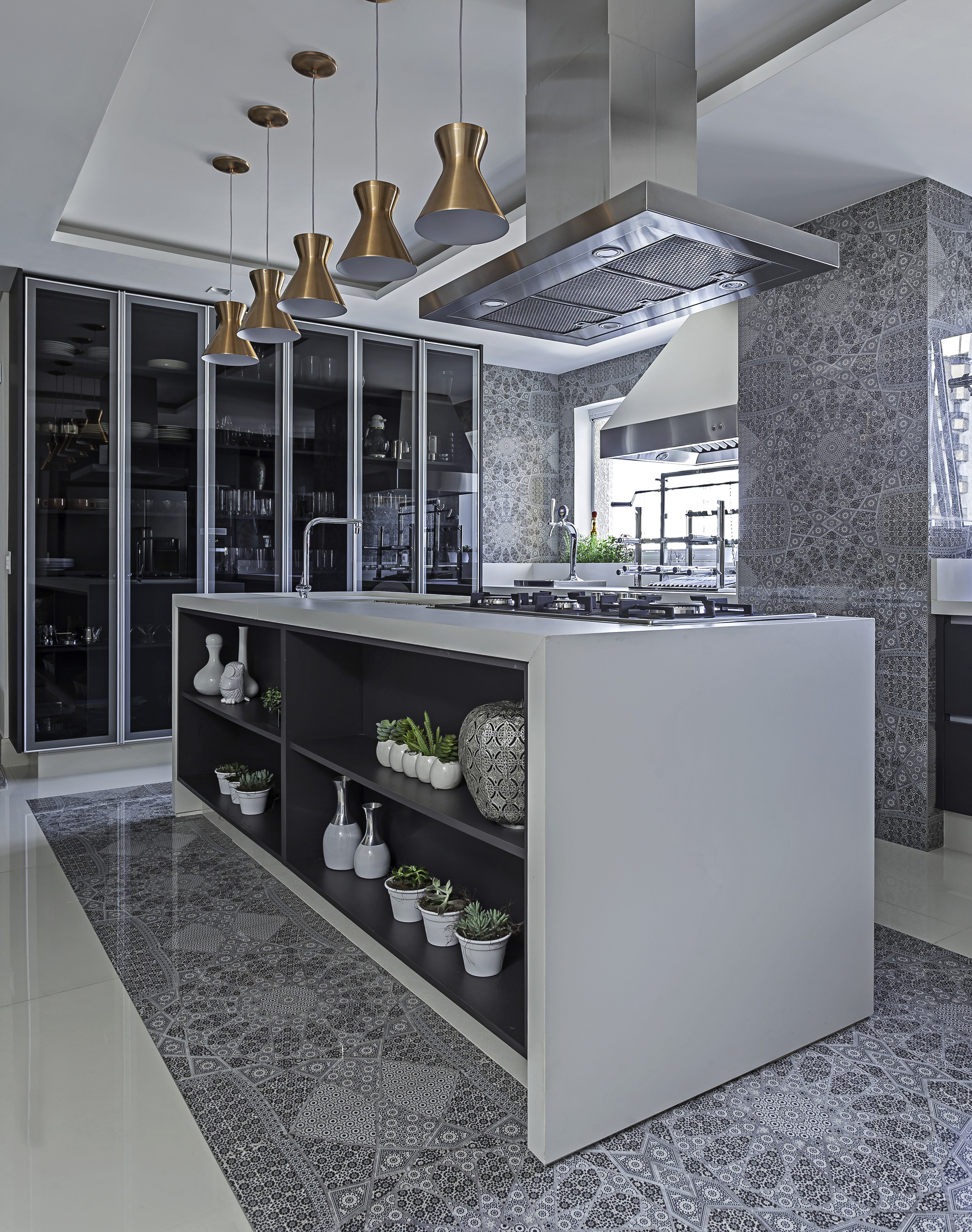 Cozinha em tons de cinza e preto com cooktop e bancada ao centro.