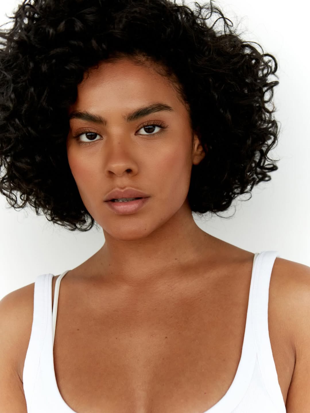 Foto de Bella Campos. Ela &eacute; negra, est&aacute; com o cabelo na altura do queixo e cacheado