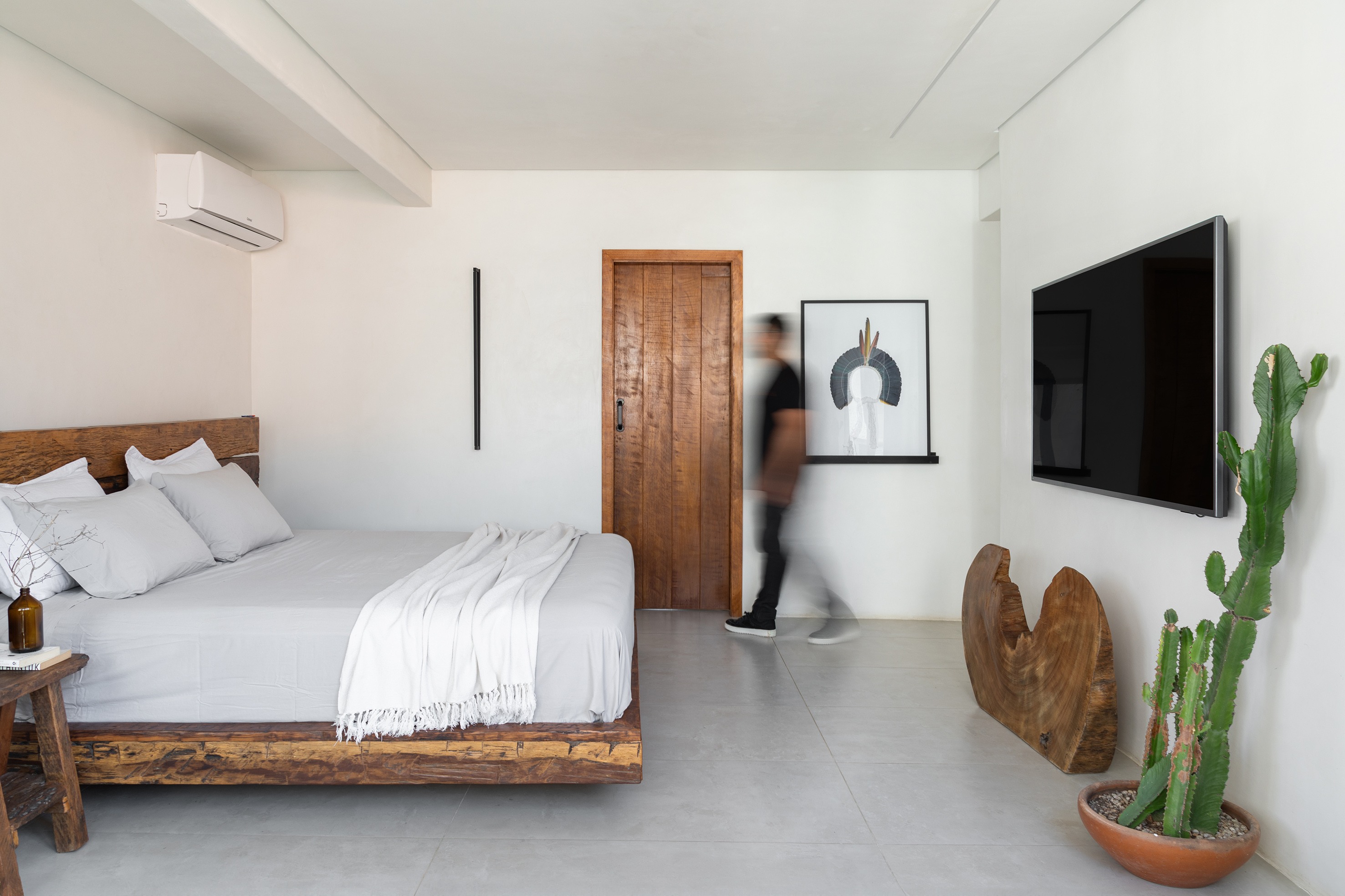 Foto de um quarto com decora&ccedil;&atilde;o predominantemente branca, com itens de madeira e cacto