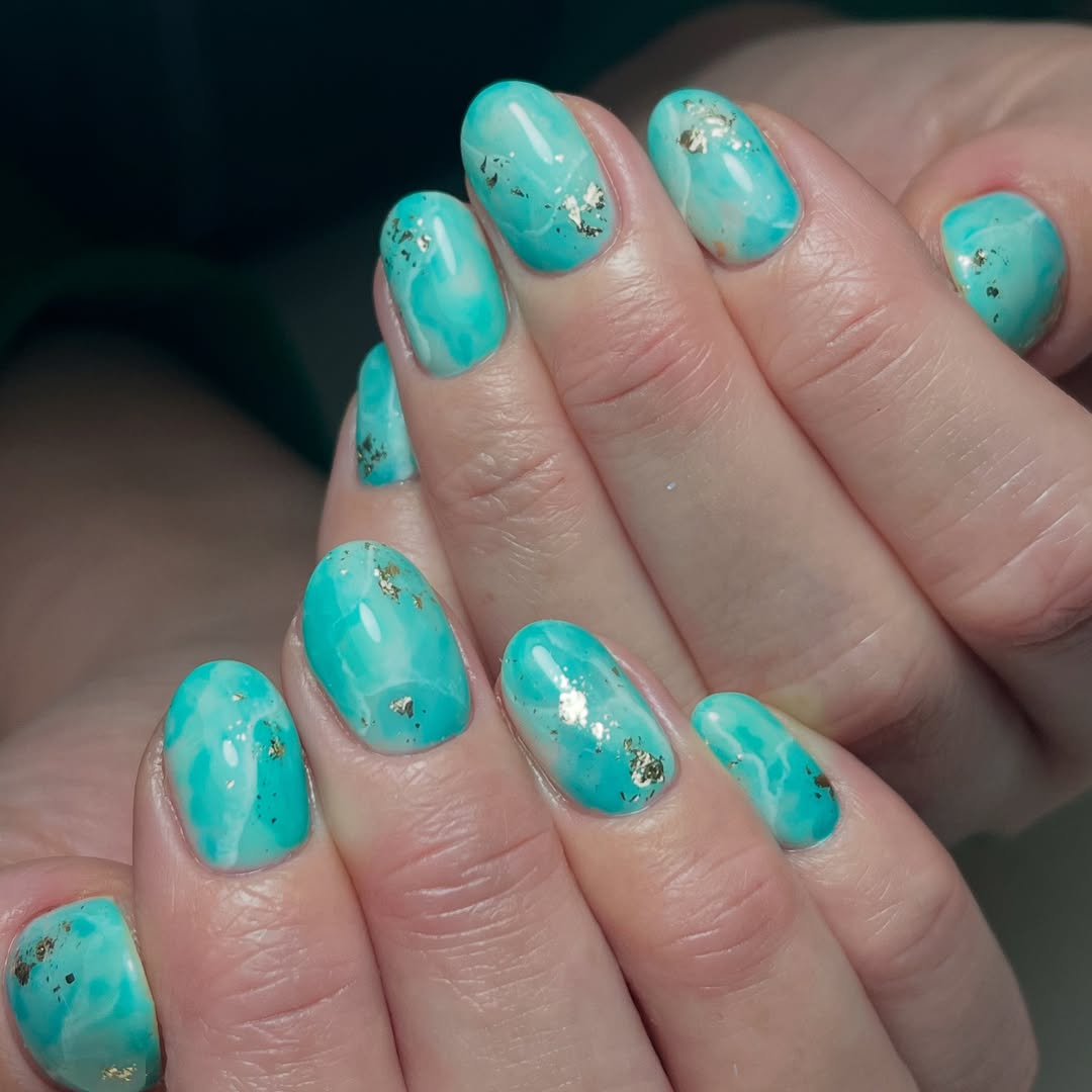 Unhas azul-turquesa com nail art delicada para o Ano Novo